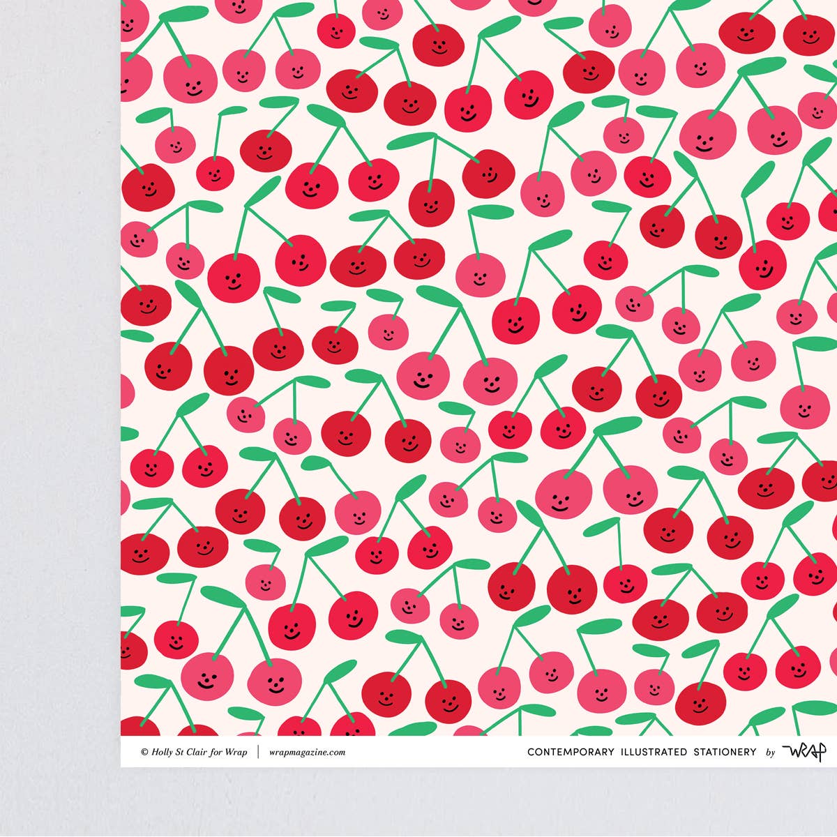 close up corner view of the gift wrap sheet with a smiley-faced cherry design all over