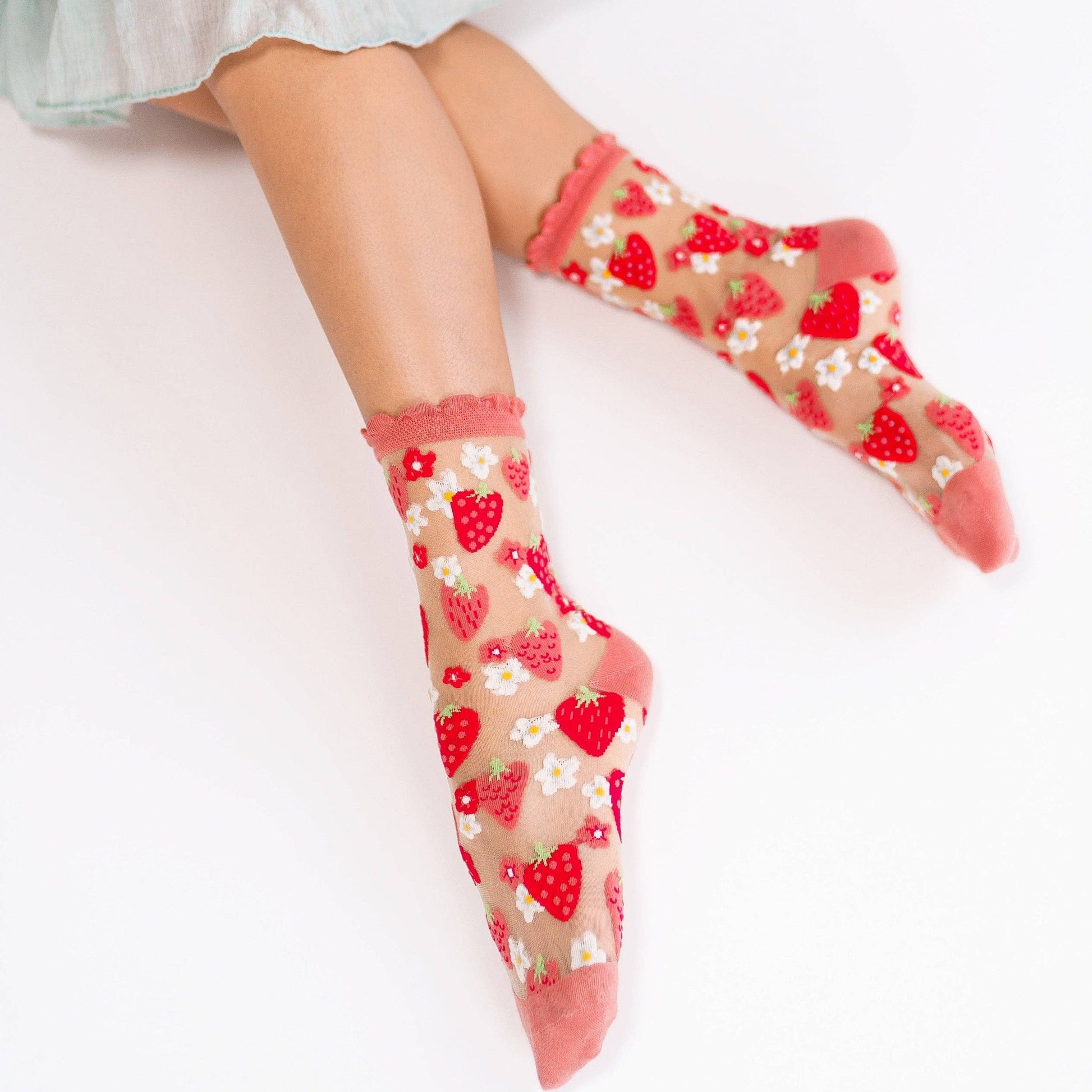 Pink and red strawberry patterned sheer crew socks on model