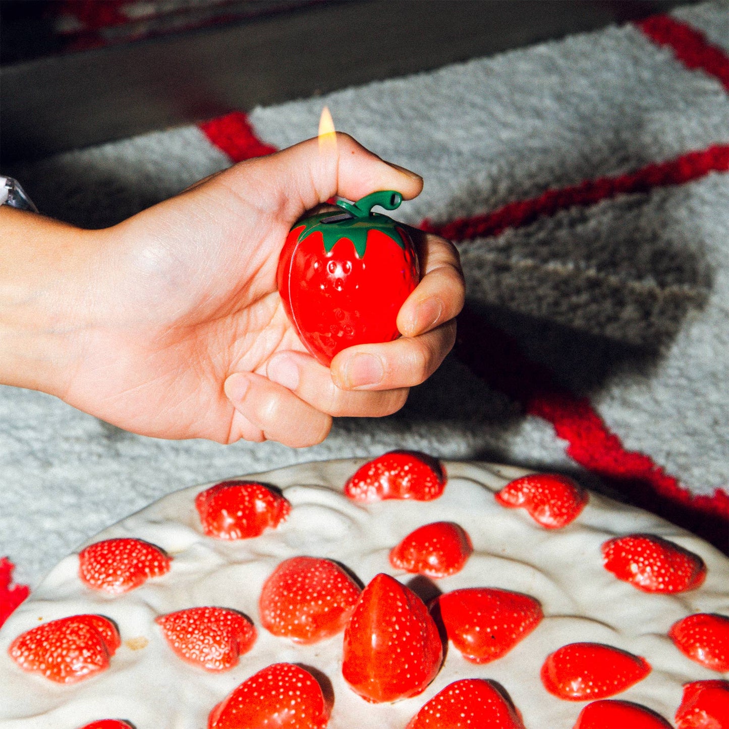 A lighter in the shape of a strawberry. Image is showcasing how it would light with fluid inside