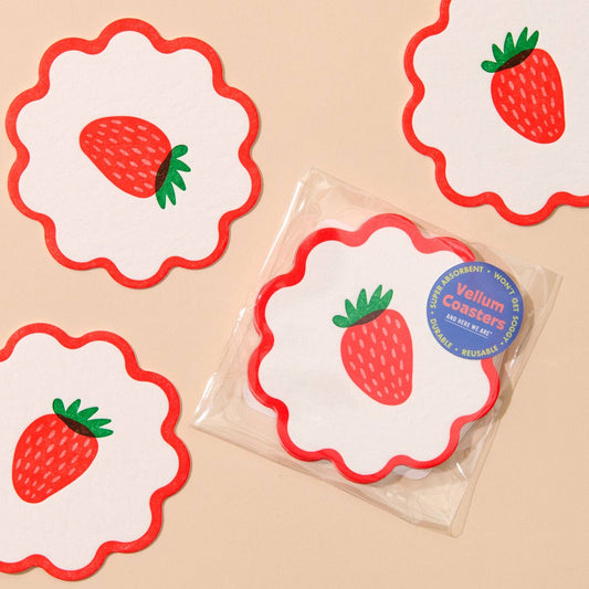 Strawberry-themed coasters with red and white design on a beige background