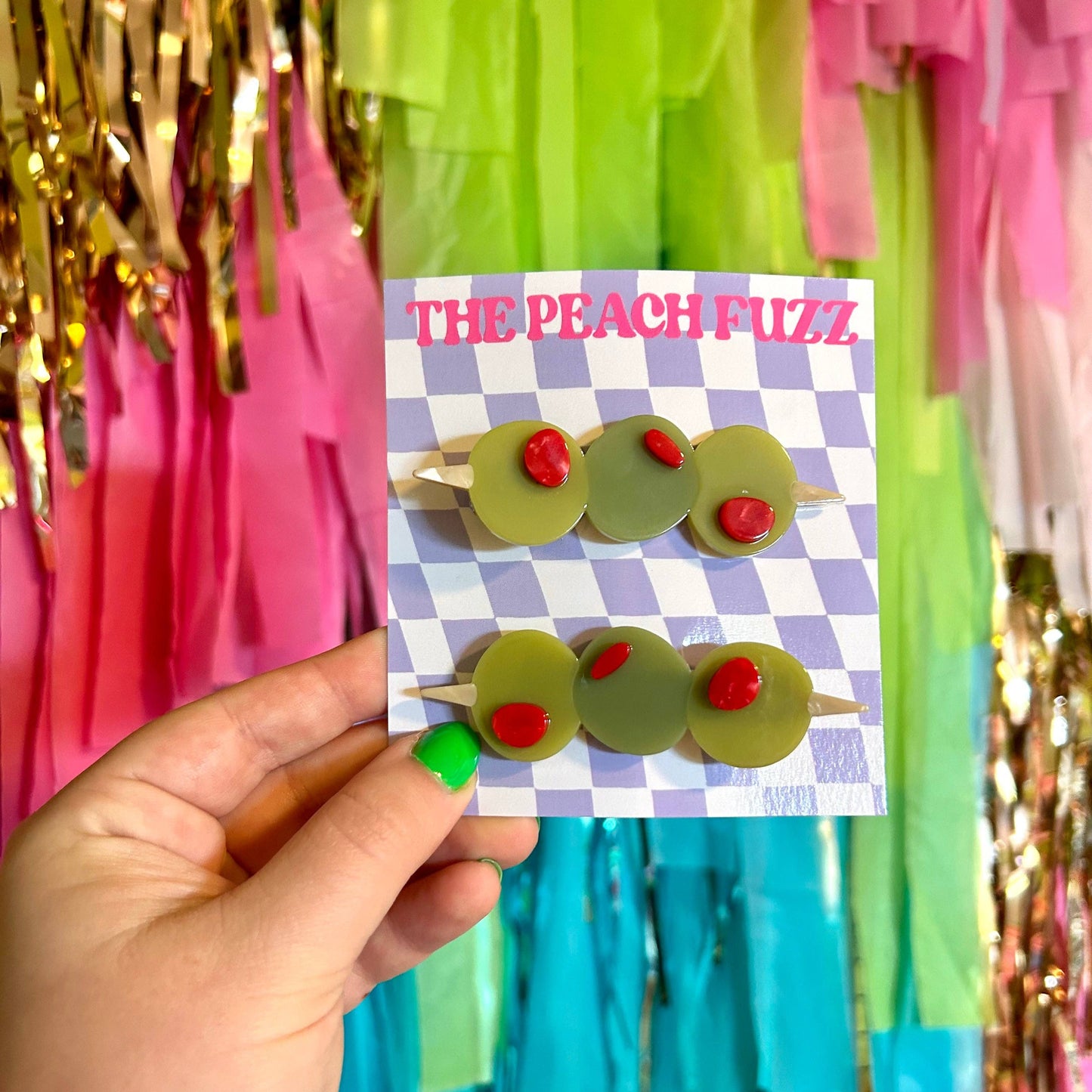 a pair of stuffed olive hair clips on checkerboard card backing
