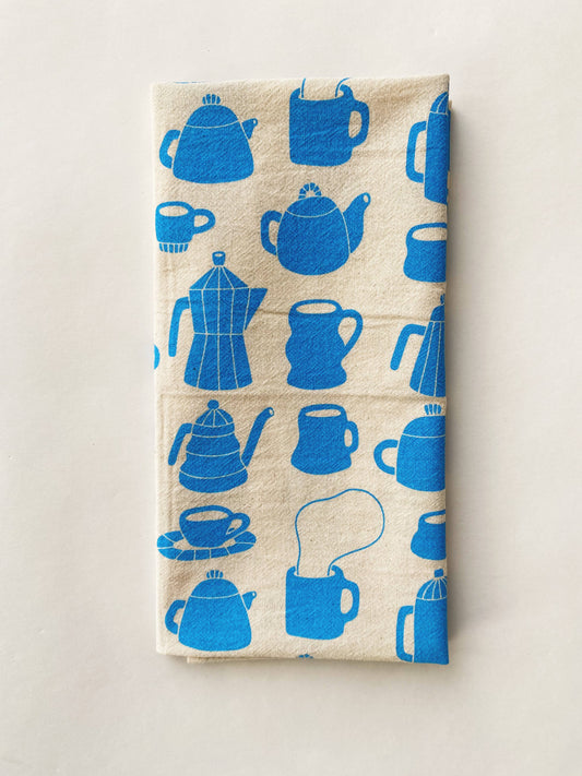Tea towel with different styles of tea/coffee pots and mugs printed in blue ink on it