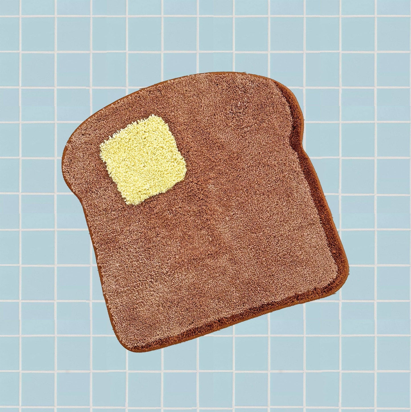rug in the shape of a piece of toast with a pad of butter on it