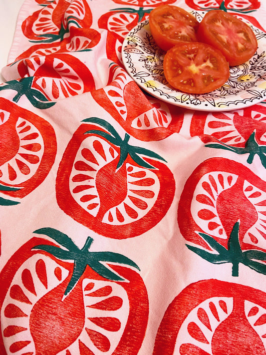 pink kitchen towel with repeated pattern of a half-cut tomato