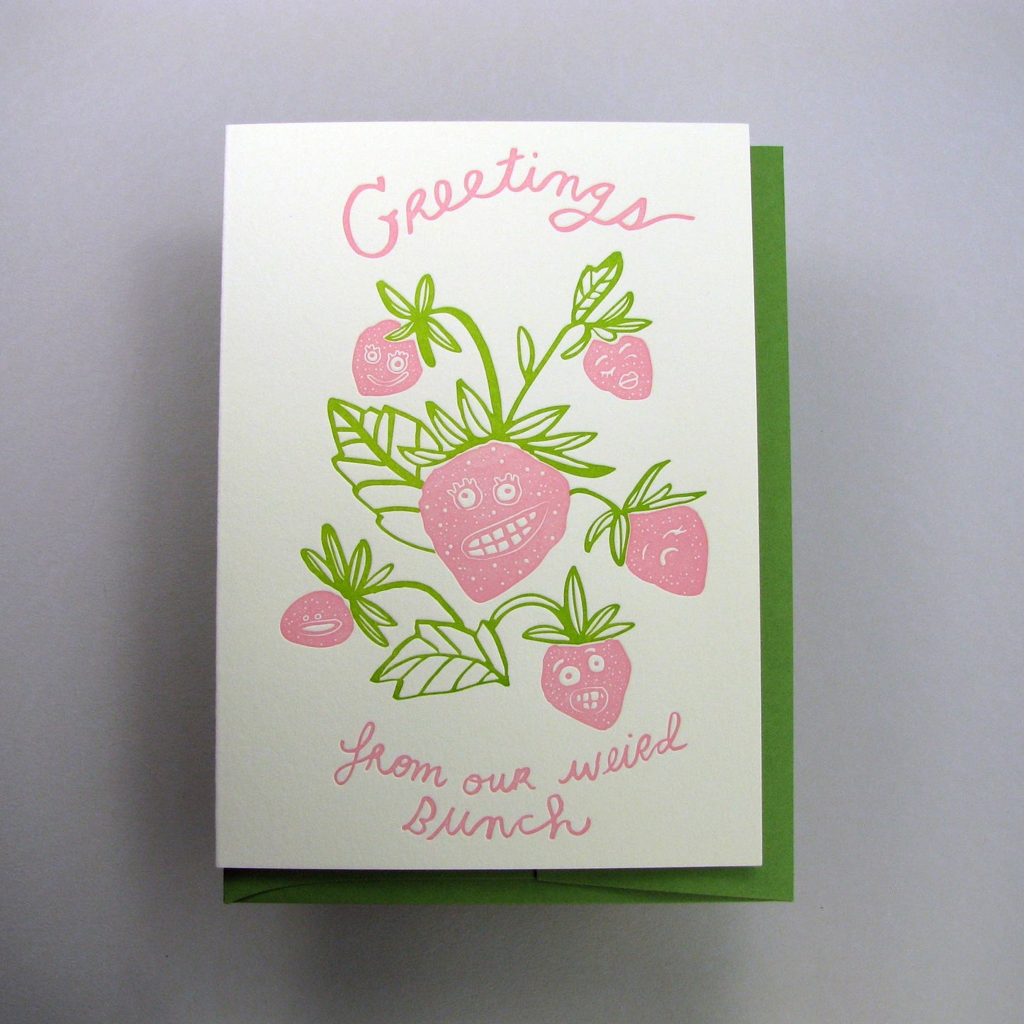 Greeting card that reads "Greetings from our weird bunch" with an illustration of a strawberry bunch with different silly faces on them