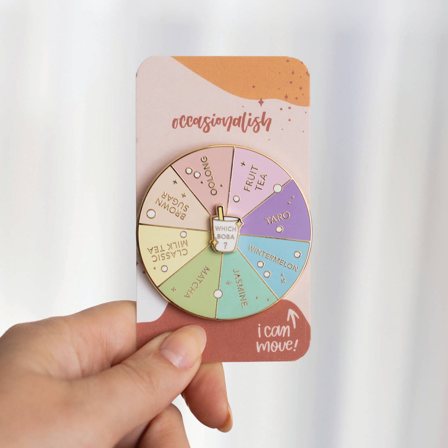 Colorful wheel with boba/bubble tea flavors on a card held by a hand against a white background