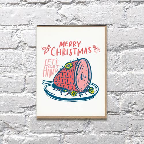 Holiday greeting card with a Christmas ham on a platter. Text reads "Merry Christmas. Let's get ham'd"
