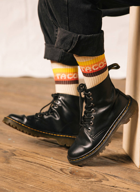 Tacos striped sock. Model is wearing Doc Martin boots and high black pants to show off the socks.