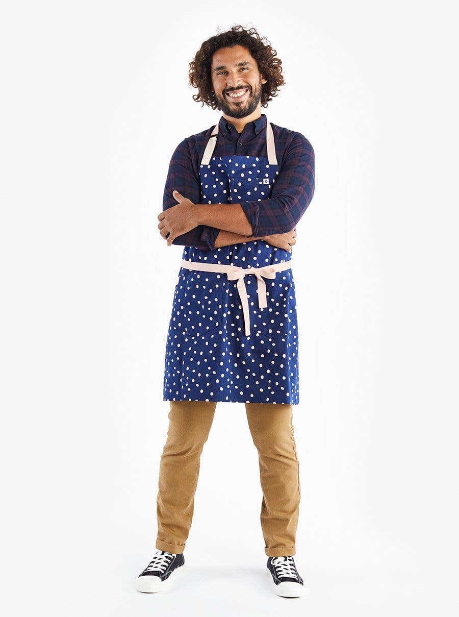 Apron worn on model -- apron is dark blue with light pink dots