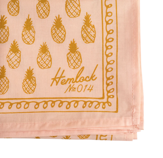 Close up of gold pineapples on light pink bandana 