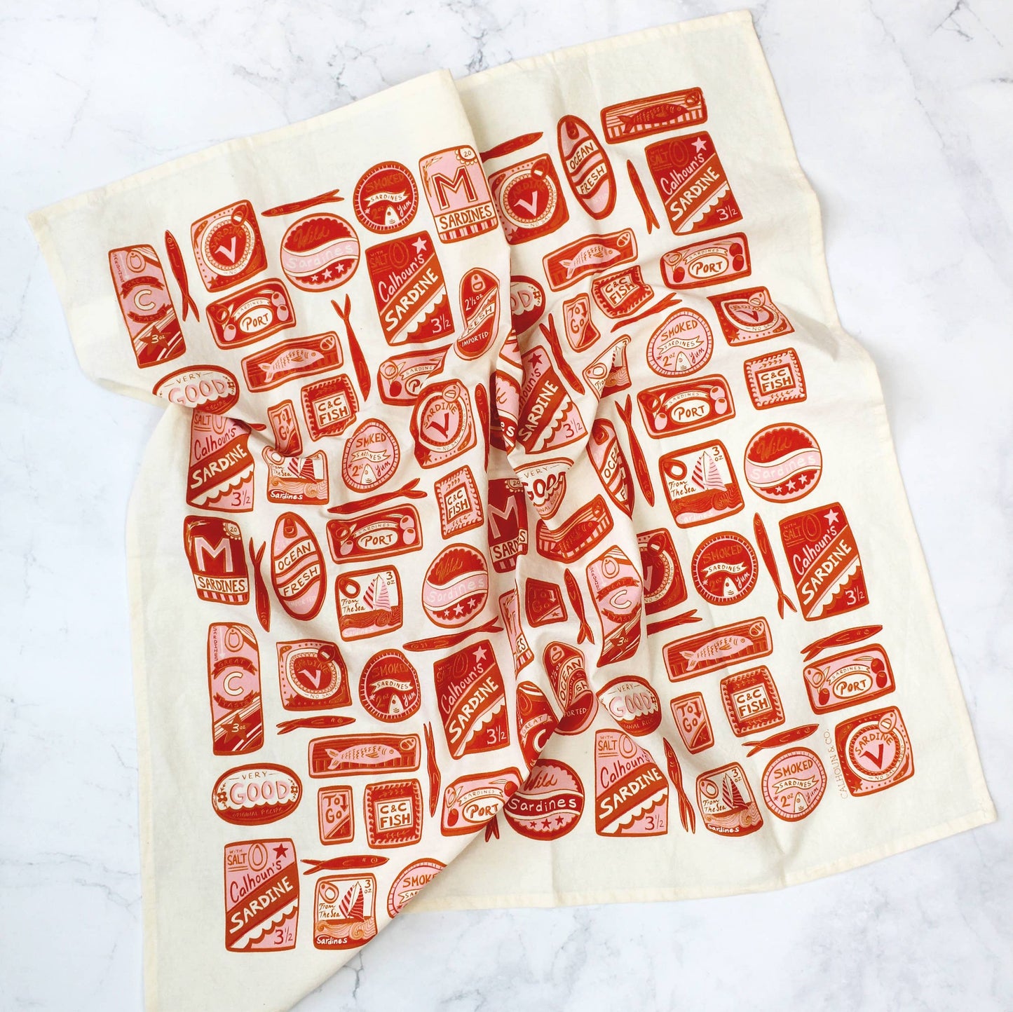 White tea towel designed with variously shaped, red, tin sardine cans.