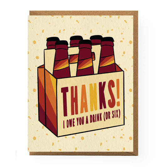 Greeting card with a six pack of beer bottles as the design. On the beer carrier it reads "Thanks! I owe you a drink (or six)" all on a gold speckled, white background. 