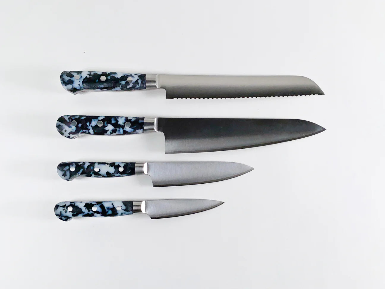 4 different knives all with black and white speckled handles
