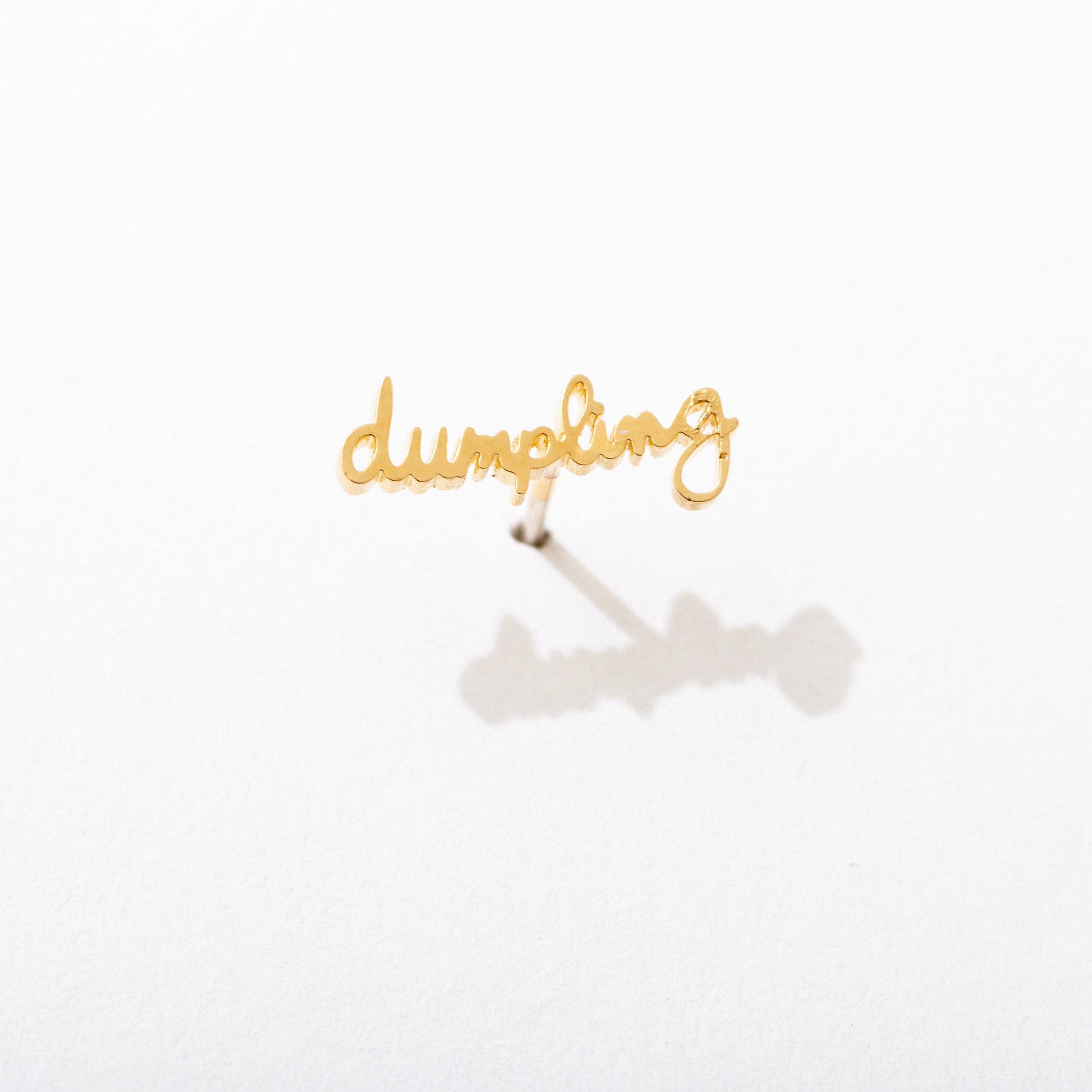 Single 14k gold plated stud earring -- reads "dumpling" in handwritten script