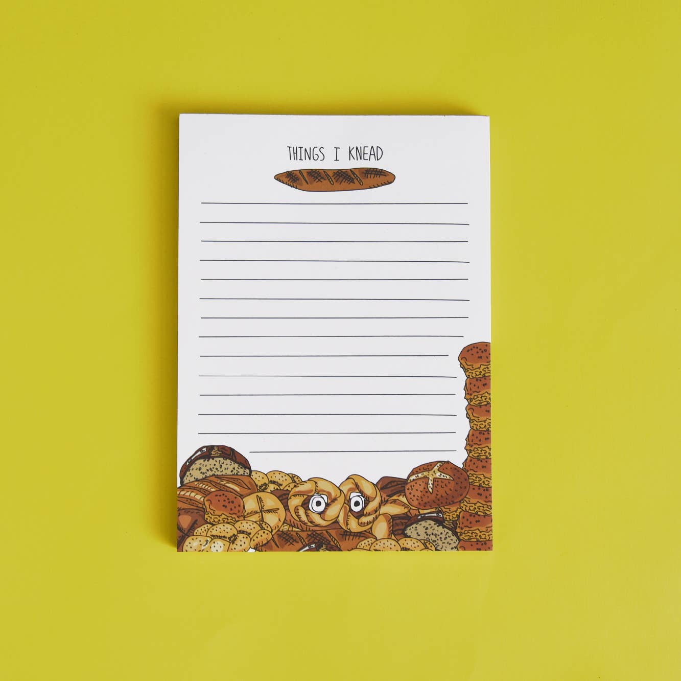 Lined notepad that reads "Things I Knead" with a baguette underneath and various breads at the bottom of the notepad