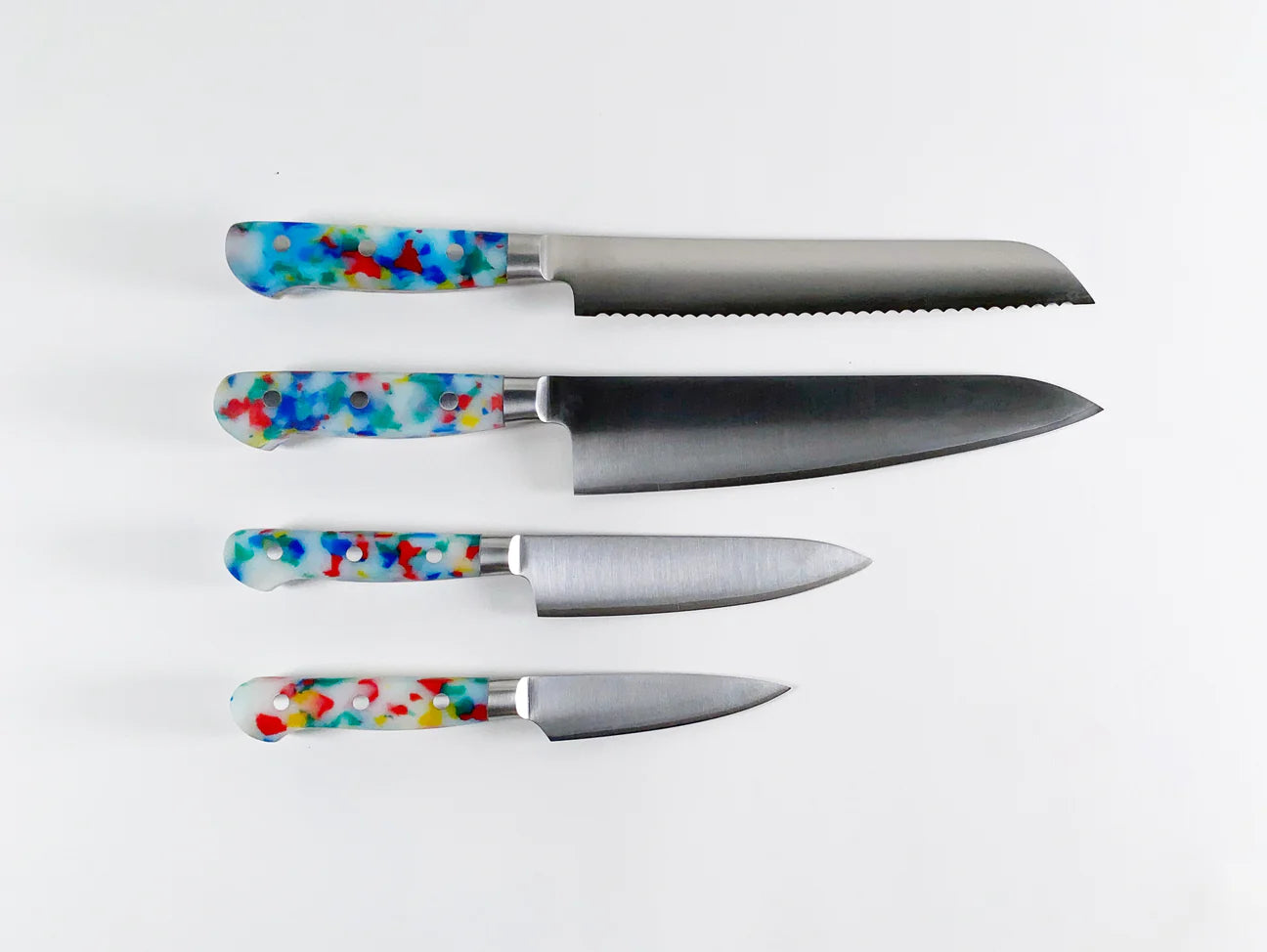 4 different knives with a multi colored handle -- mostly white with blue, yellow and red specks