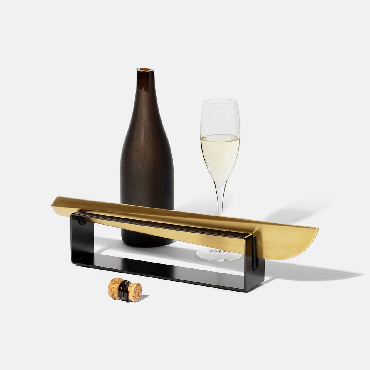brass colored, modern champagne saber with black stand