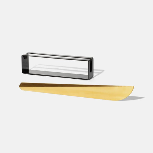 modern, brass colored champagne saber with black, rectangular stand