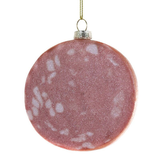 Round pink slice of mortadella ornament with white speckles on a white background
