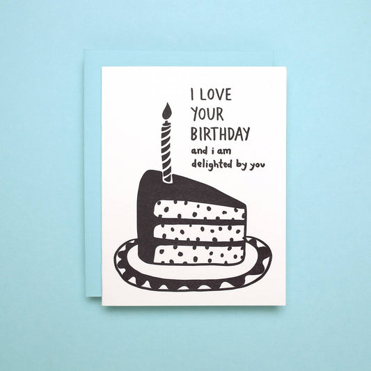 Birthday greeting card with a slice of cake on a plate with a single candle on it. Text reads "I love your birthday and I am delighted by you" 