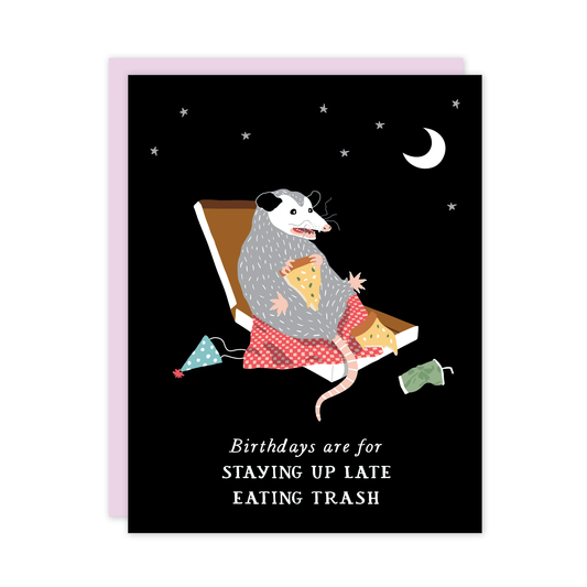 Card with illustration of an opposum  in a pizza box eating pizza, with text 'Birthdays are for staying up late eating trash' on a black background.