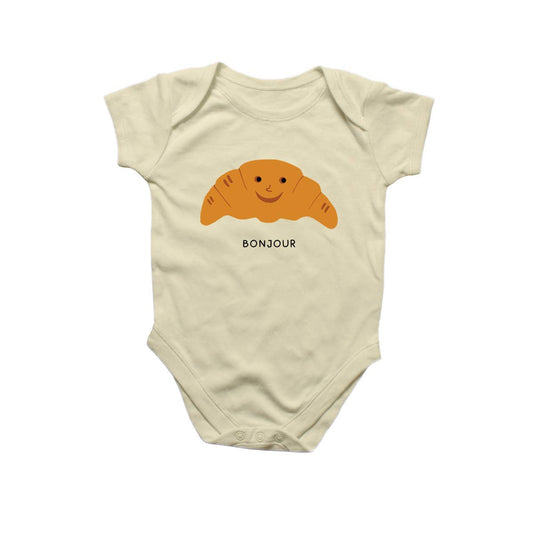 Baby onesie w/snap closure on bottom -- has a smiley faced croissant in the center with the word "Bonjour" underneath