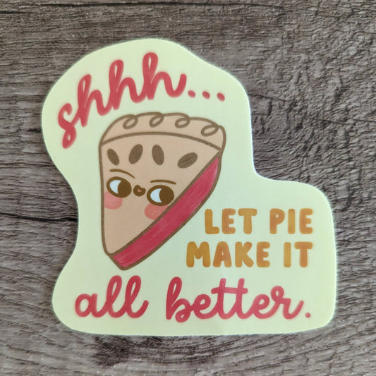 Sticker with an illustrated slice of pie on it. Text reads "shhh...let pie make it all better" 