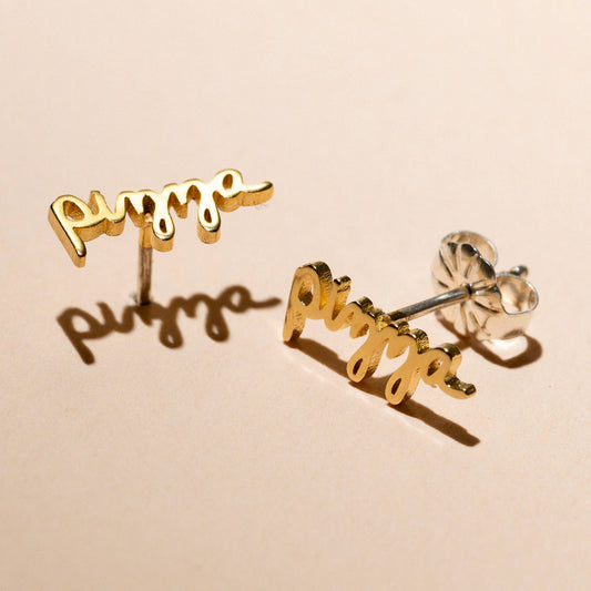 Gold plated stud earrings that read "pizza" in script 