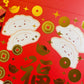 close up of gold foiled red envelopes with happy dumplings on them 