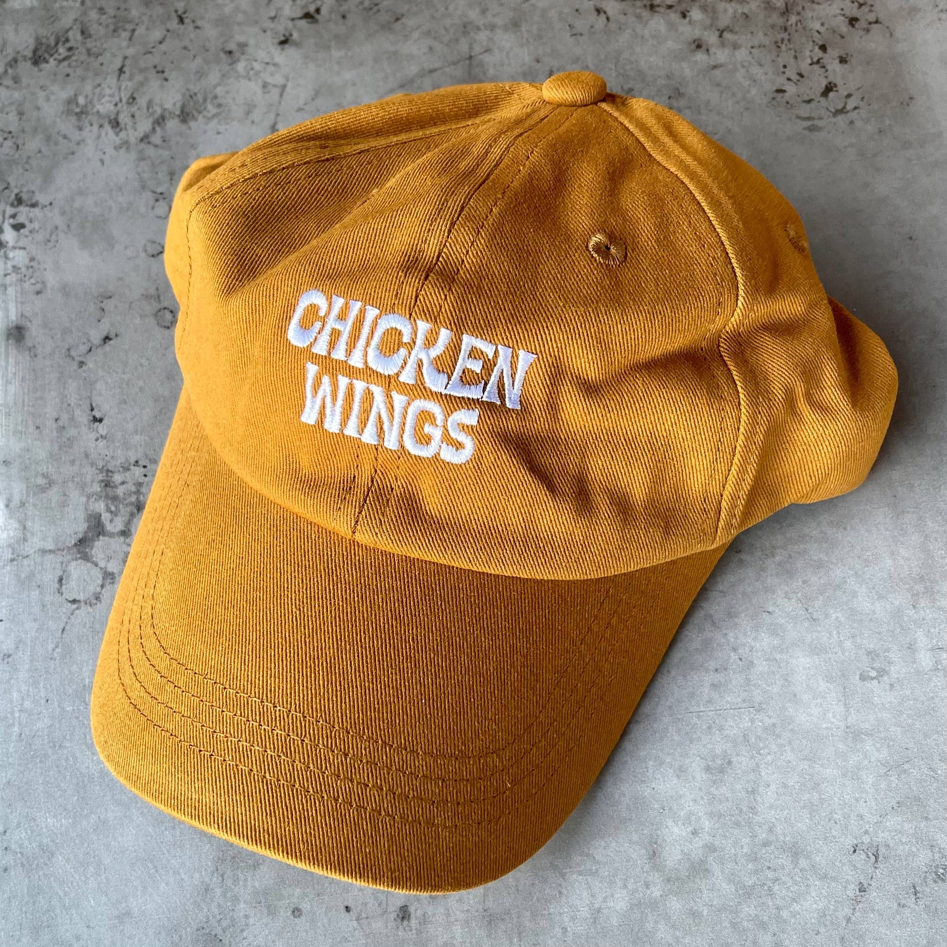Front of baseball cap -- embroidered text that reads "chicken wings" 