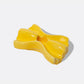 Yellow bowtie pasta-shaped candle holder on a white background