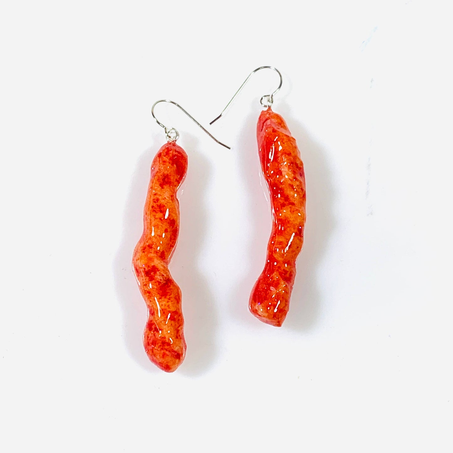 Pair of hot cheetos coated in resin and  turned into earrings