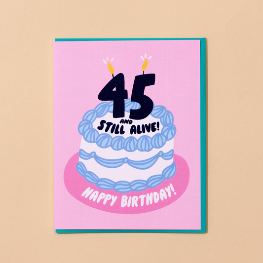 birthday card with illustration of birthday cake and 45 number candles on top along with text that says "45 and still alive! Happy birthday!" 