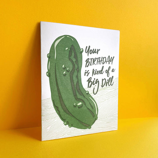 Greeting card with a large dill pickle on it with text that reads "Your birthday is kind of a big dill" 