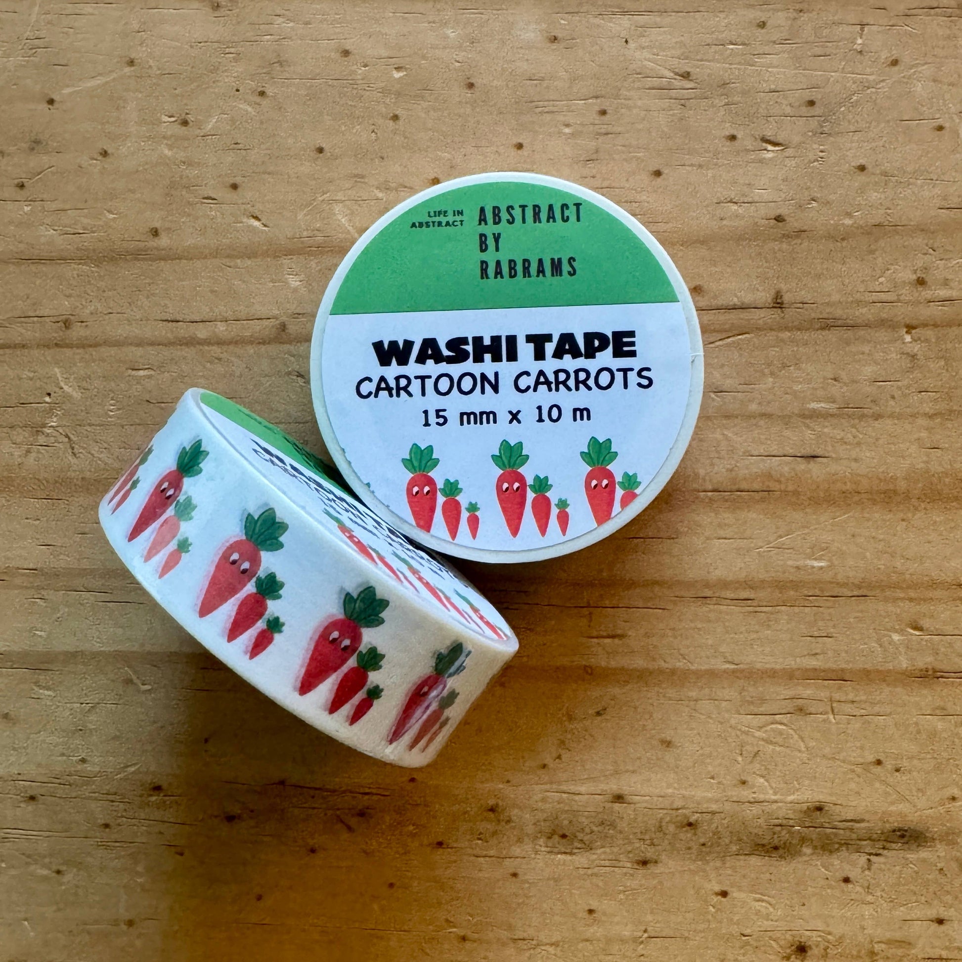 Roll of cartoon carrot-themed washi tape on a wooden surface
