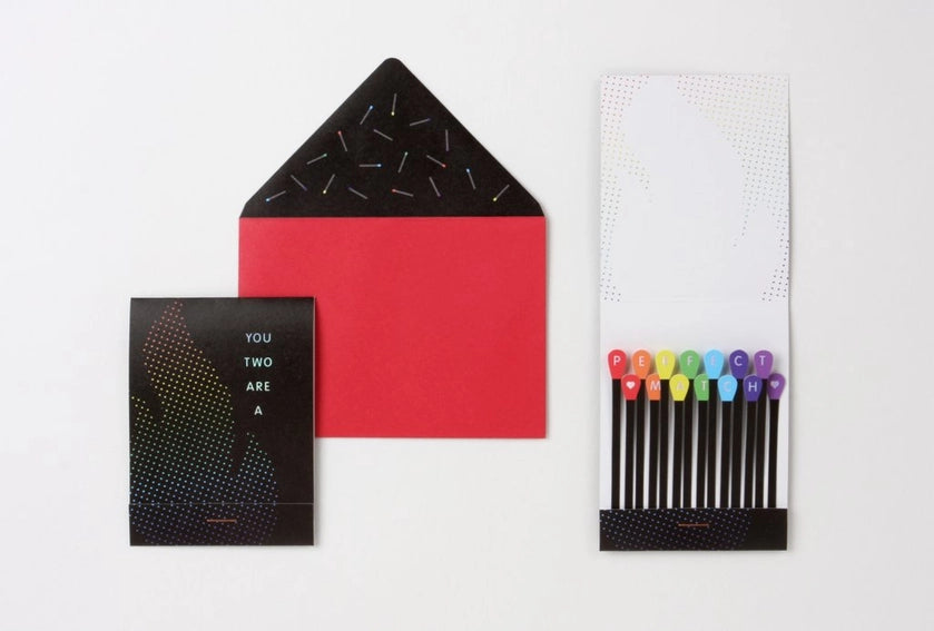 Photo shows front of matchbook shaped greeting card, inside of card with rainbow matches, and corresponding red/black envelope. 