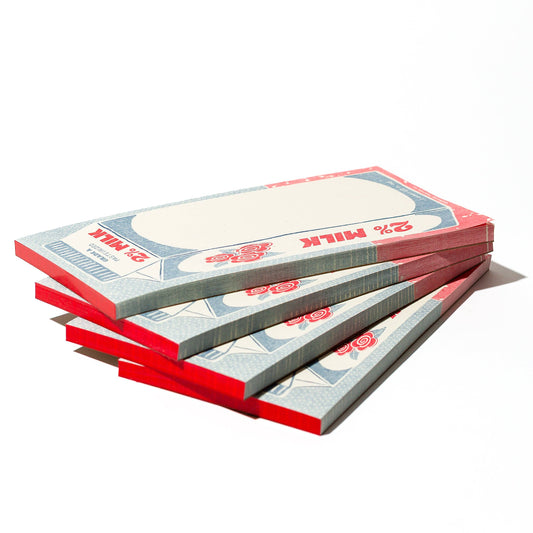Stack of milk carton notepads on a white background