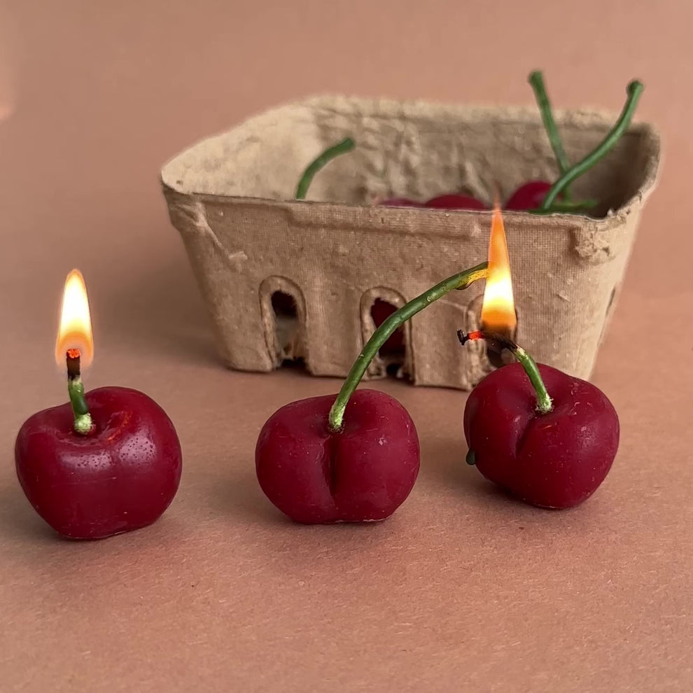 Realistic cherry candles burning from the stems