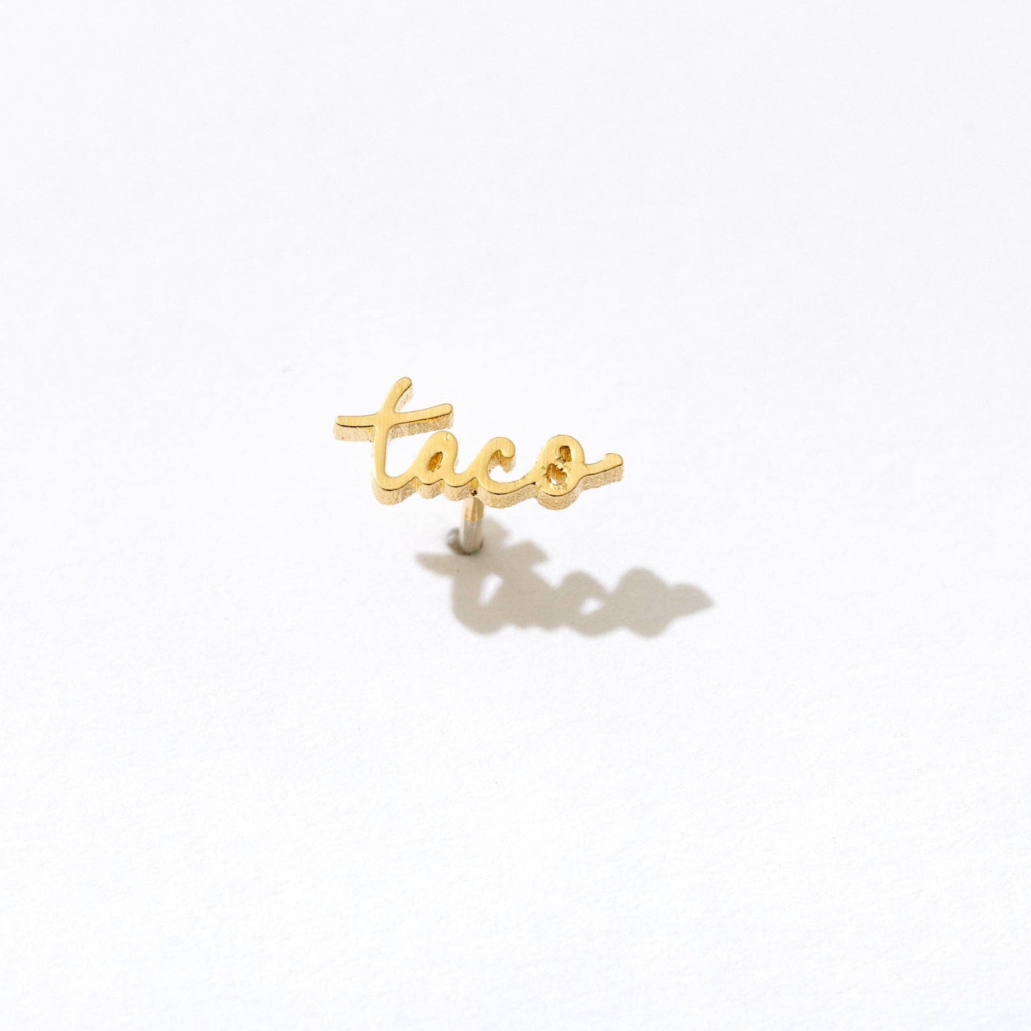 Single stud earring -- 14k gold plated text in script writing that reads "taco" 
