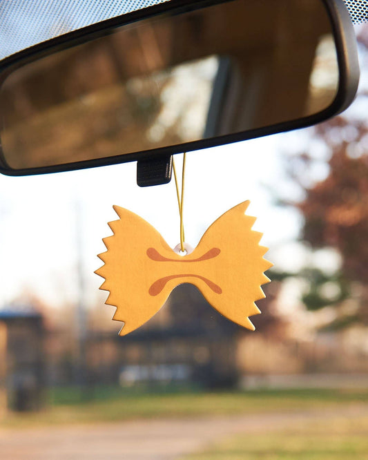 Car air freshener made to look like farfalle (bowtie) pasta hanging from rearview mirror 