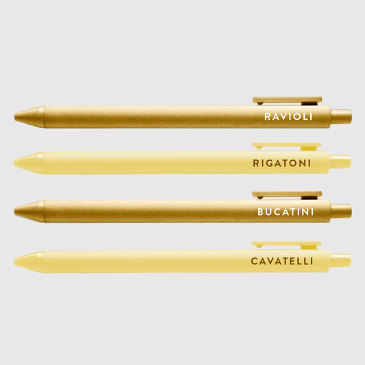Set of 4 pasta pen set with text -- pen barrels are either gold or light yellow. Text on gold pens read "ravioli" and "bucatini", text on light yellow read "rigatoni" and "cavatelli" 