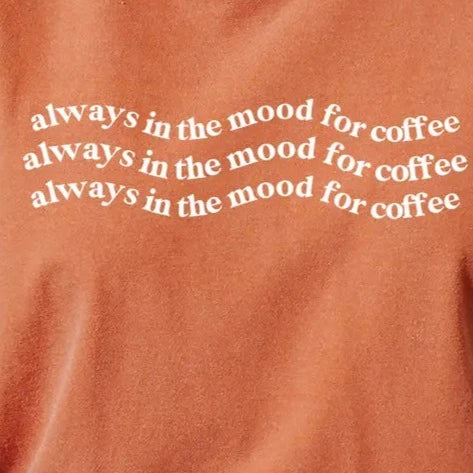 Close-up of text "always in the mood for coffee" repeated three times in wavy pattern.