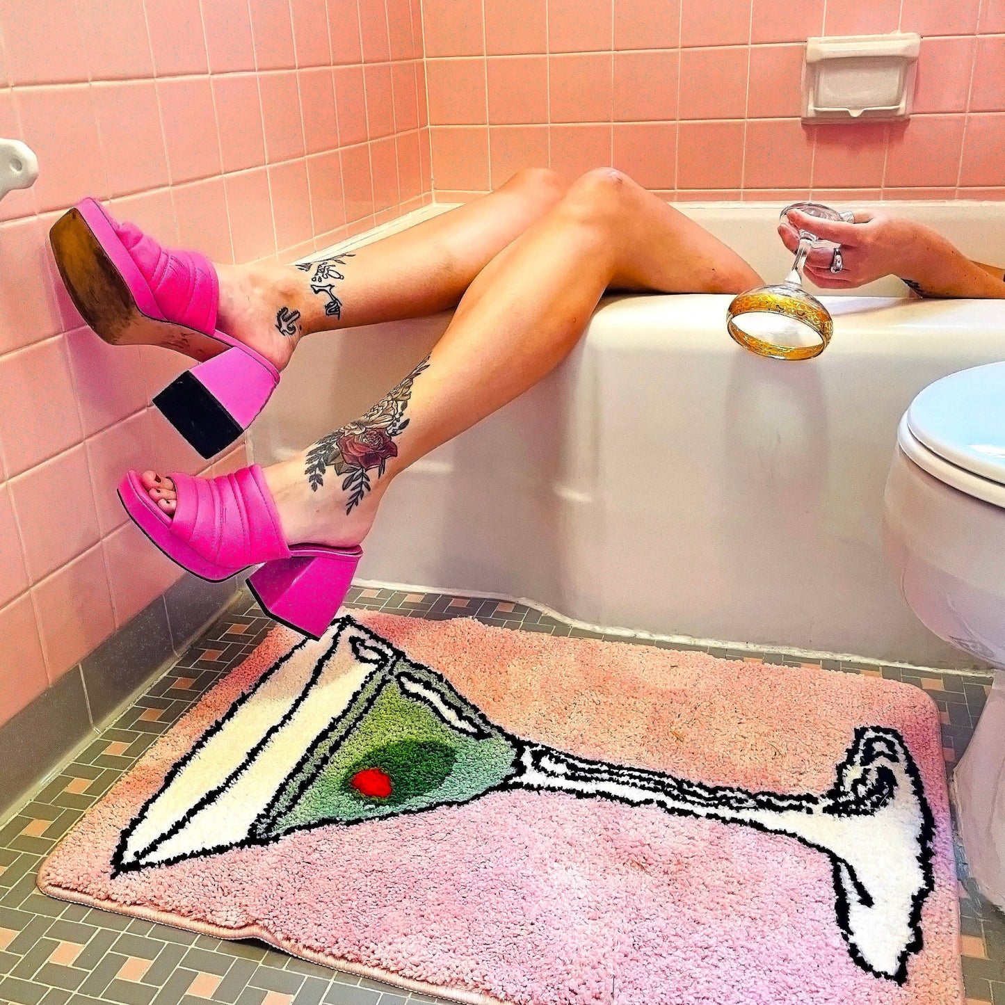 Pink rug with a martini on it in a bathroom 