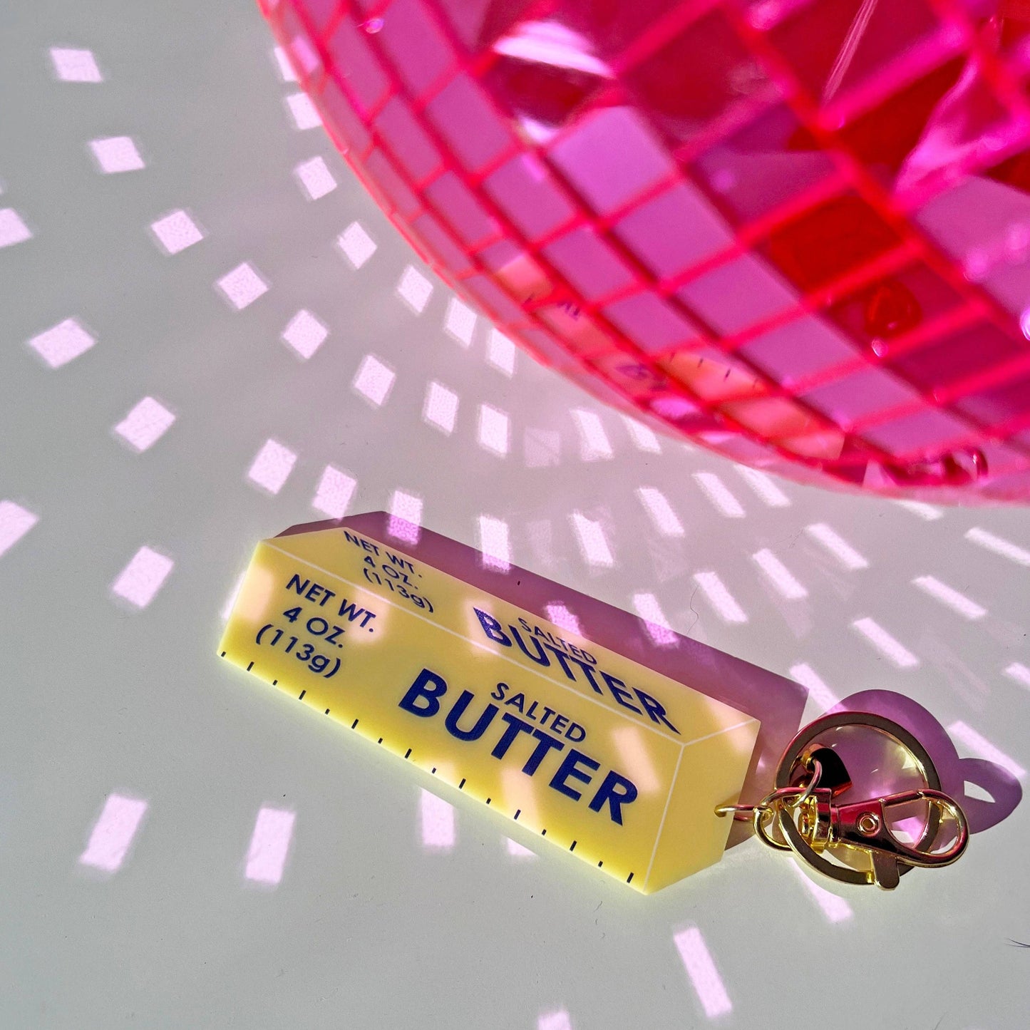 Keychain that looks like a stick of salted butter with a pink disco ball 