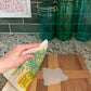 Photo of dill sponge cloth being used to clean up a spill on a cutting board.