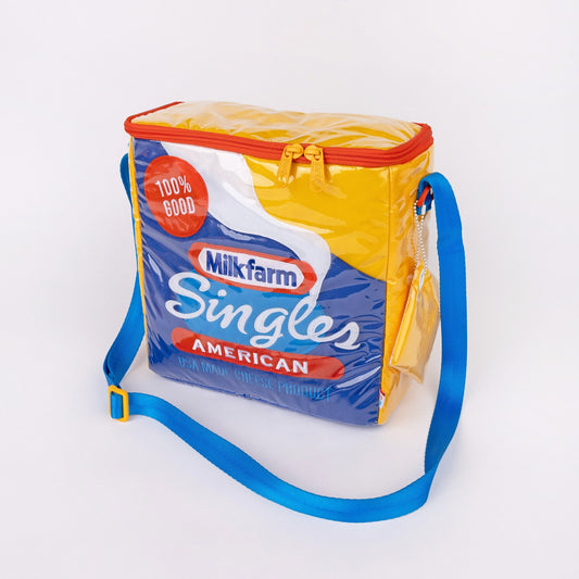 Milkfarm Singles Cheese Bag that looks like a Kraft Singles package. Multicolored with blue, white, red and mustard coloring. Text also says "100% Good/ American/ USA Made Cheese Product."
