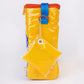 Milkfarm Singles Cheese Bag that looks like a Kraft Singles package. Multicolored with blue, white, red and mustard coloring. Text also says "100% Good/ American/ USA Made Cheese Product." This photo is a side view showing a bonus key chain that looks like a slice of cheese in its celophane wrapper.