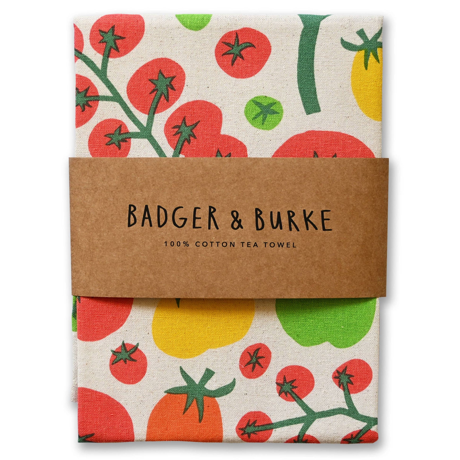A folded cotton tea towel with a colorful tomato print, wrapped in a brown paper band that reads 'BADGER & BURKE 100% COTTON TEA TOWEL'.