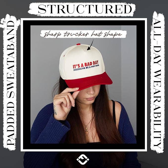 Person wearing a white and red cap with text, against a gray background
