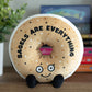 Bagel plushie sitting on a bookshelf